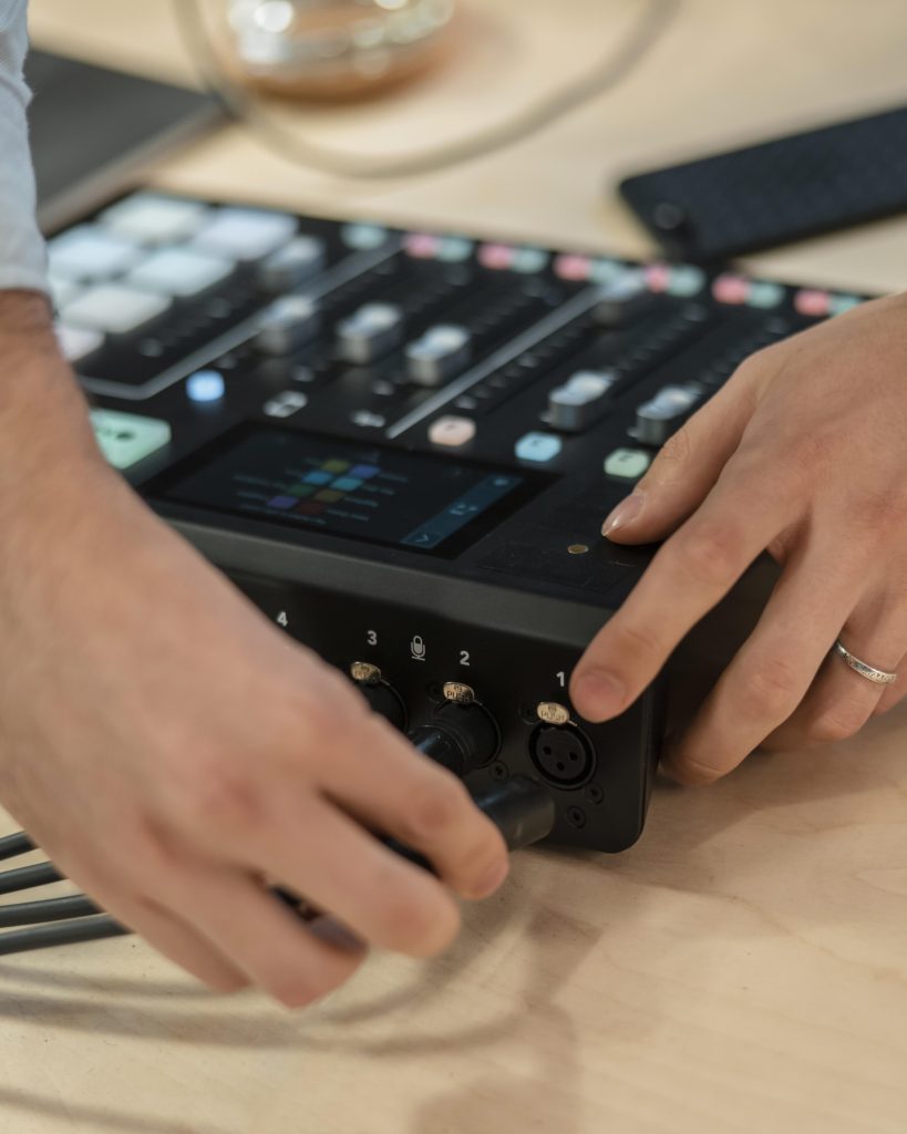 Mesa de mezclas de sonido profesional con perillas, faders y conexiones para micrófonos y auriculares. Equipo esencial para grabación de audio, producción musical y mezcla en estudios de sonido y podcasts.